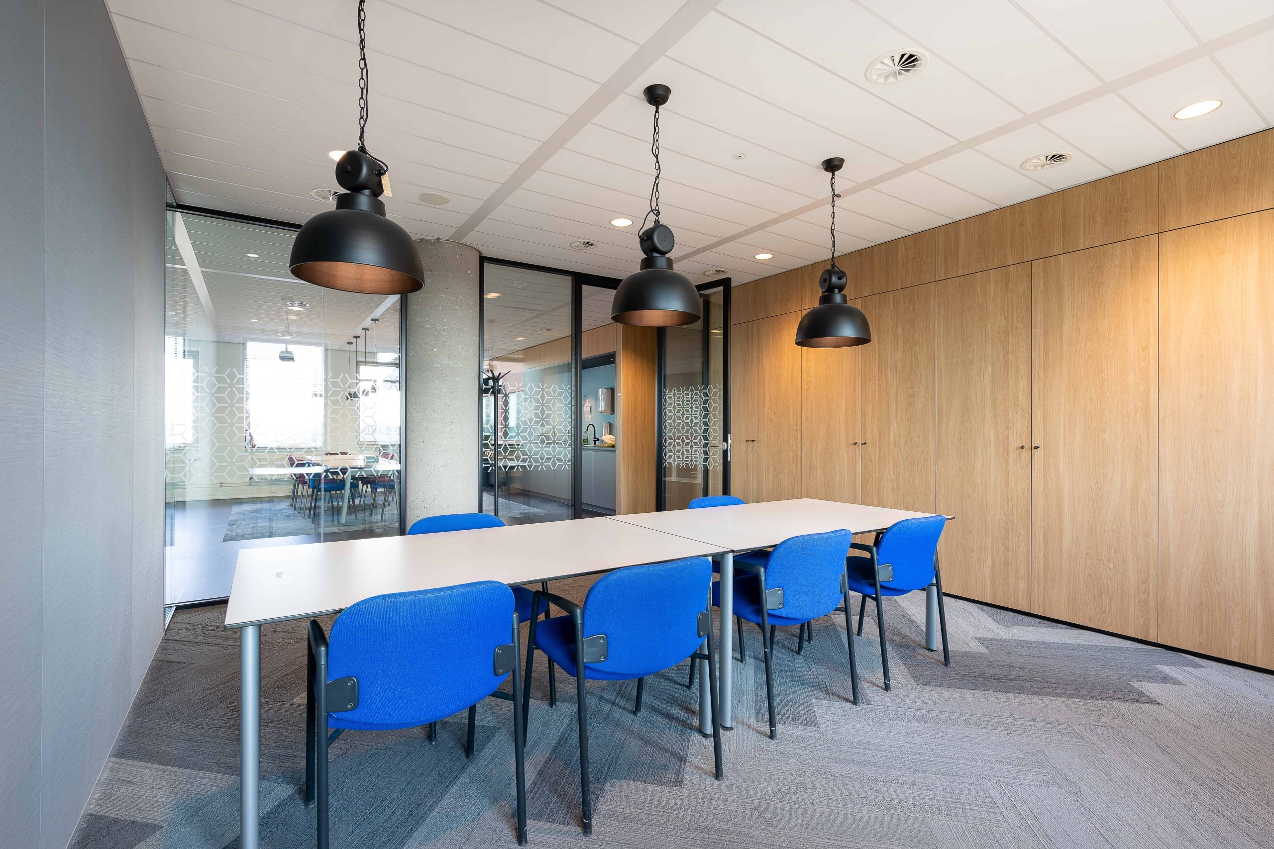 interior-de-la-sala-de-reuniones-de-una-oficina-moderna-con-una-larga-mesa-de-madera-y-sillas-su-alrededor (1)